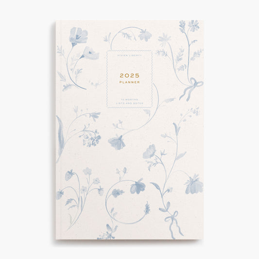 Cottagecore aesthetic book-bound planner notebook with monthly and weekly calendar, project timelines, goal tracking. Cover art style is floral pattern, toile, dutch, blue, delft, ribbon bows, wildflowers.