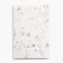 Cottagecore aesthetic book-bound planner notebook with monthly and weekly calendar, project timelines, goal tracking. Cover art style is floral pattern, toile, dutch, blue, delft, ribbon bows, wildflowers.